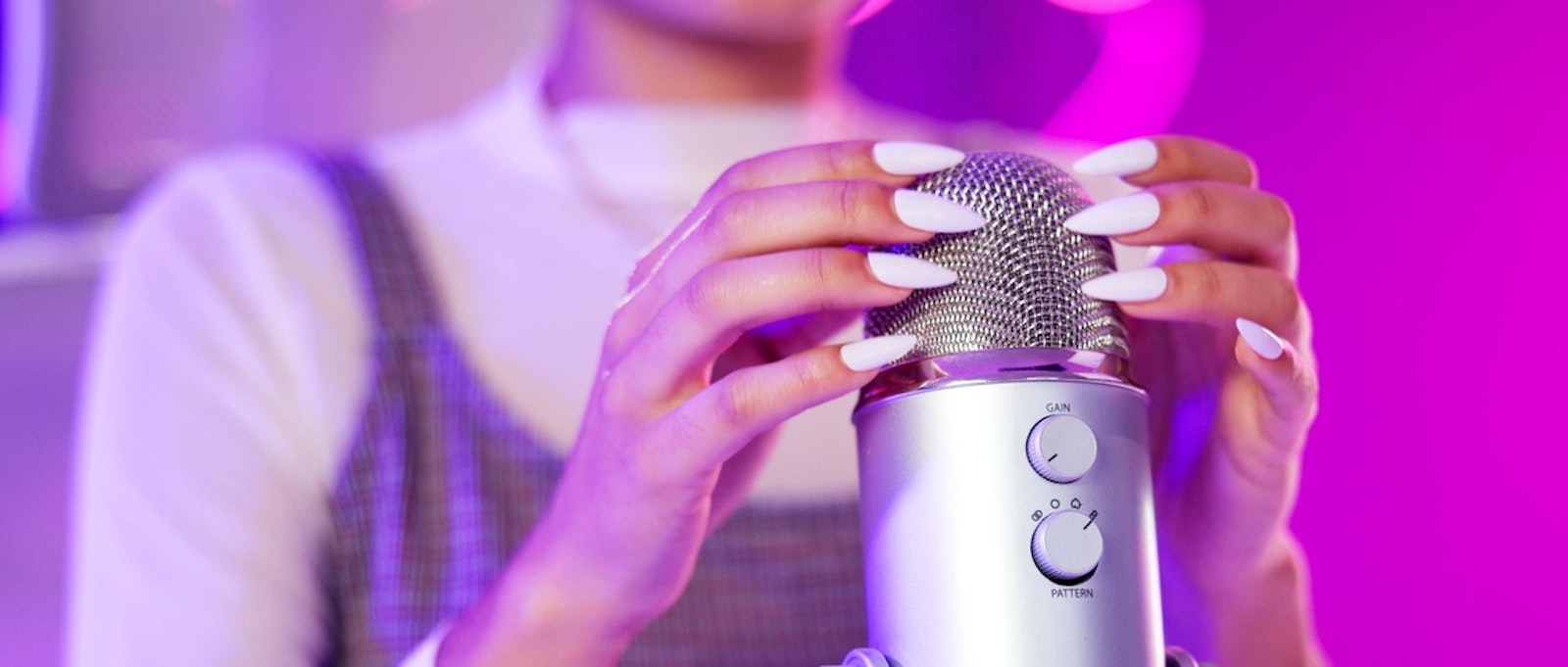 Nails, ASMR and hands with microphone, woman and neon lights with podcast, content creation and tech. Home, broadcast and audio for stress relief with person influencer with recording for sound