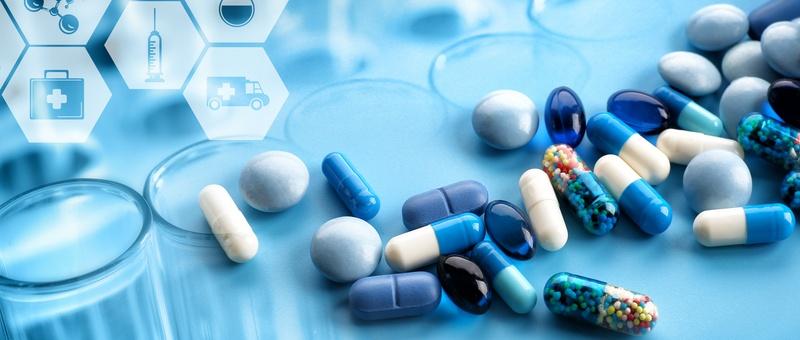 Assorted blue and white pharmaceutical pills and capsules on a blue surface with medical icons in hexagonal shapes.