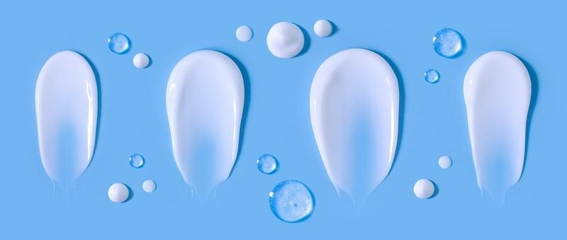 Cosmetic smears cream texture on pastel blue background.