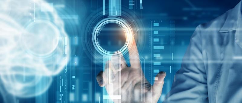 Hand touching a glowing digital interface with circular elements and data visualisations in blue tones.