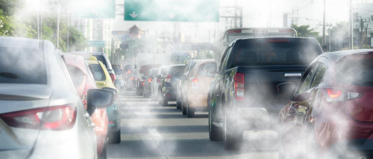 Cars in traffic with exhaust fumes.