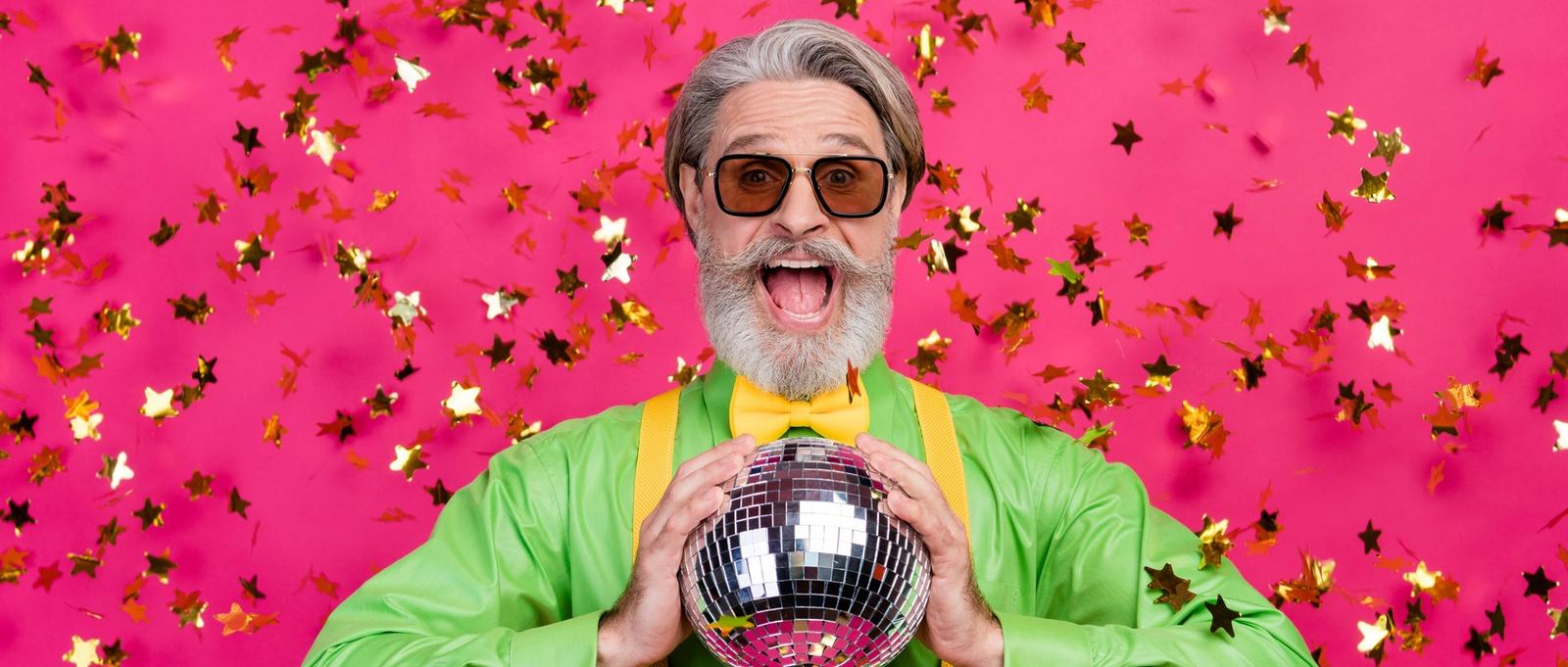 Photo of funny grandpa party club confetti fall excited open mouth hold glowing disco ball wear sun specs green shirt yellow suspenders bow tie, isolated shine pink colour background
