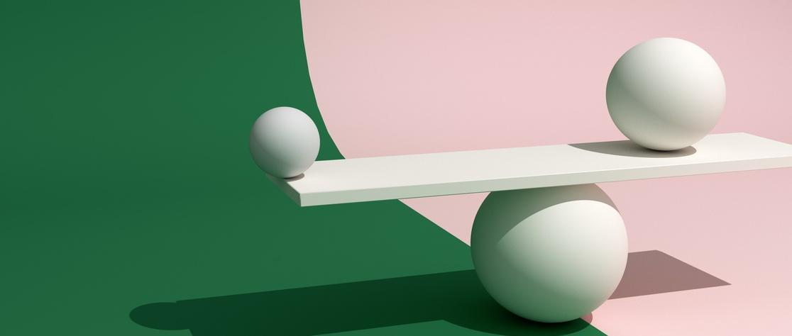 Pale balls balancing on plank against green and pink background