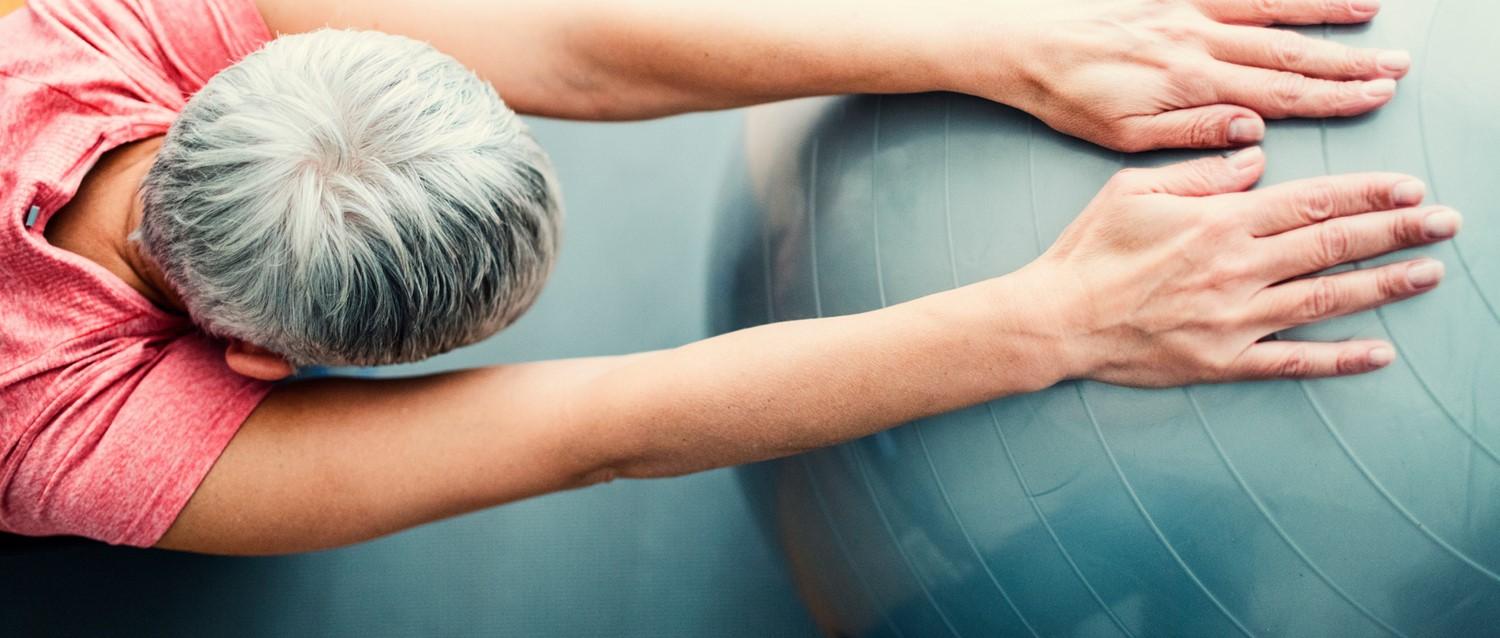 Mature woman exercising with yoga ball