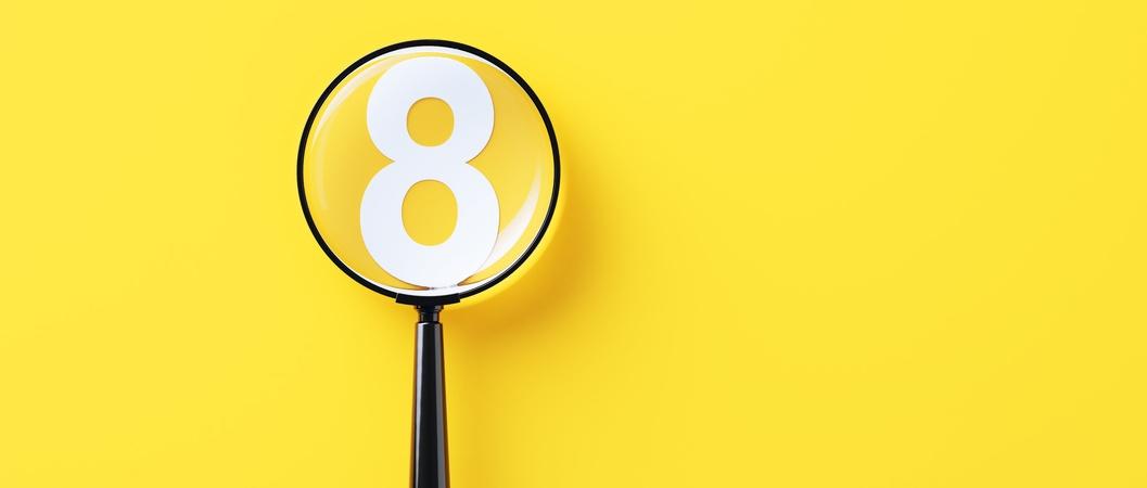 Black magnifying glass and white number eight on yellow background.
